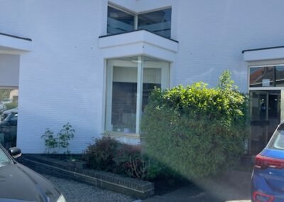 Buitenschilderwerken aan de gevel van Garage Philips in Klei, Opwijk met strakke witte afwerking.
