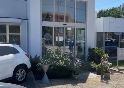Buitenschilderwerken aan de inkomgevel van Garage Philips in Klei, Opwijk met een moderne witte afwerking.