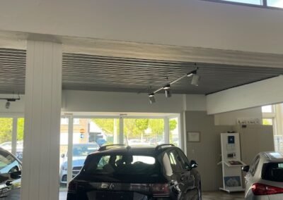 Professionele schilderwerken in de showroom van Garage Philips in Klei, Opwijk met strak afgewerkte muren en kolommen.