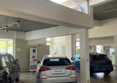 Strak geschilderde showroom van Garage Philips in Klei, Opwijk met nette afwerking van plafonds, muren en kolommen.